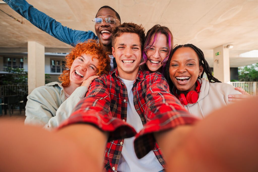 Smiling multiracial group of teenage friends taking a selfie together