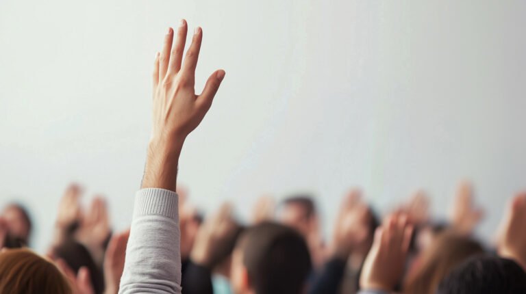 Student raising a hand in a crowded classroom