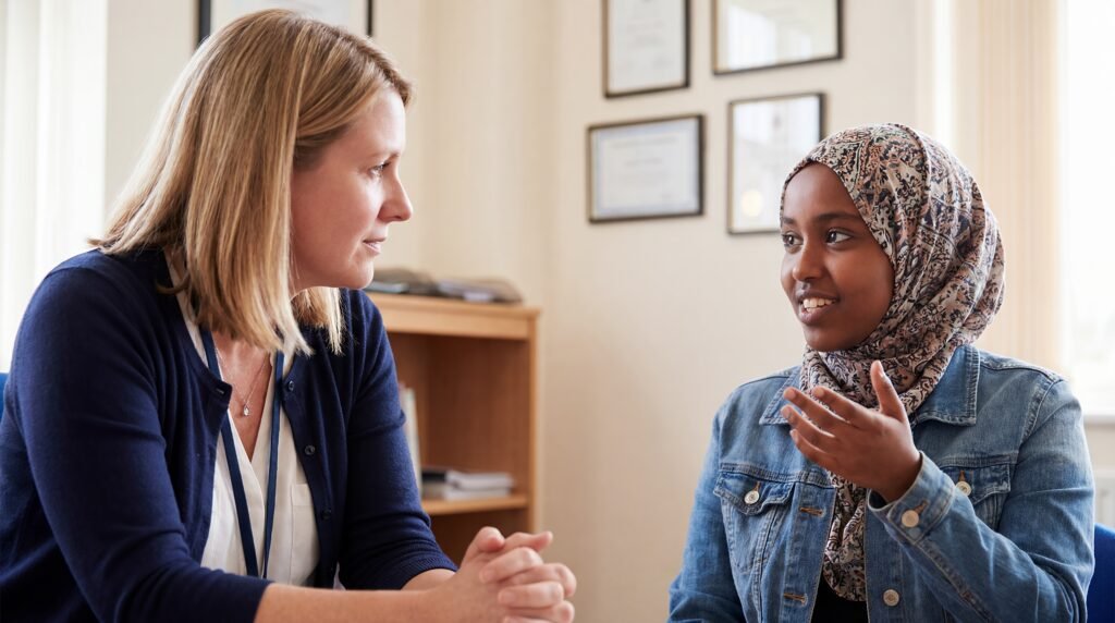 A school counselor listening closely to a teenage student during a one-to-one conversation